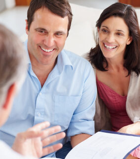 Happy middle aged couple meeting with financial advisor